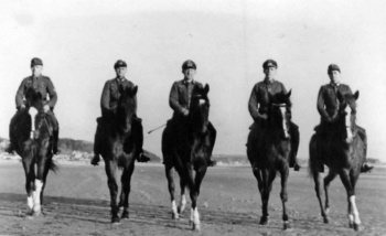 German cavalry officers exercise their mounts on the beach at Beaumont