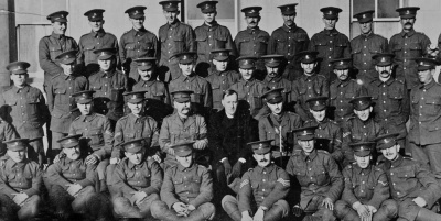 Jersey Contingent volunteers from 2nd (East) Battalion gather for a photo with Reverend D.D. Love who presented them with gifts from the YMCA committee at the end of February 1915. They are assembled at St Martin’s School, which had been taken over as battalion HQ at the outbreak of war. The Contingent’s commanding officer Lieutenant Colonel Walter Stocker is sitting on the reverend’s right, while second-in-command Captain George Johnson is probably the officer seated on his left. Captain Johnson has the sad distinction of being the Contingent’s first death in action – killed by an enemy shell near Vermelles on 1 April 1916.