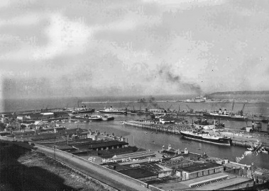 On South Pier is Johann Ahrens which had arrived the previous Thursday with a cargo of timber. On the North Pier is Stephaniewhich arrived on Friday from Finland, again with timber. At No 1 Berth Albert Pier is the week old Brittany which was about to leave on an excursion to Sark. At No 3 Berth is Isle of Sark which was about to depart, and at No 4 was Isle of Jersey which had arrived on the Sunday, and would depart the next day. In the No 6 berth on the North Quay was St Julien. In this picture Isle of Sark is departing through the pierheads