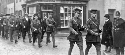 Two smart lieutenants lead a column of South Staffordshire men through St Helier – they are a mix of new recruits still in their civilian clothes and probably recalled reservists who have retained their army uniform.