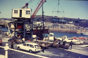 Cars being craned on to a cargo vessel for the journey to St Malo in the early 1970s. Their owners caught up with them later travelling on a Condor hydrofoil