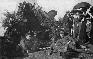 Militia soldiers relax while visitors to the camp look on