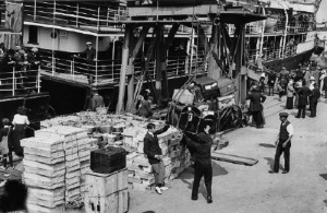 A ship is unloaded in the early 20th century