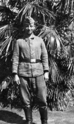Soldier posing in front of palm tree