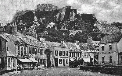 The railway has arrived and Carrel's Temperance Hotel can be clearly seen in the middle of the photograph, with a horse-drawn carriage about to pass it. Also shown in the picture are Stevens' Eastern Railway Tearooms, Marshall's Cadena Tearooms, Nelson House tearopoms, and Single's Mont Orgueil tearooms.