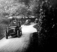An early picture by Albert Smith of cars in a country lane
