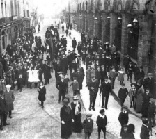 In 1914 a large crowd attending the funeral of Dorothy Rodda made its way down the street, followed by a carriage, photographed by Percival Dunham