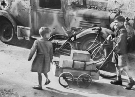 Boys return home with their family's parcels in a home-made barrow