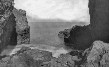 Looking out to sea between the rocks at either side of the cave