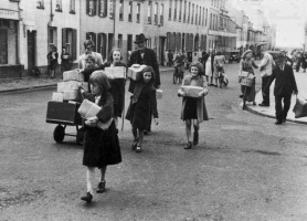 A wider view of the iconic picture of the family taking their parcels home shown in the box at the top of the page