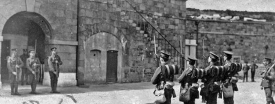 In early May 1915, the Militia’s 3rd (Town) Battalion moved from its temporary barracks in the Canning Factory at Grève d’Azette into Fort Regent following the departure of South Staffordshire Regiment troops. This image from that date shows a changing of the guard at the fort.