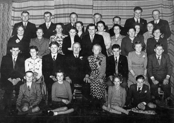 Alfred and Louisa with their children and grandchildren. Back row: Fred, 1907; Mark Pirouet, husband of Louisa Surcouf; Clarrie, 1921; Arthur, 1910; Edward, 1909; Ken, 1932 son of Fred; John, 1909; Second row: Gladys Le Moignan, 1907 wife of Fred Surcouf; Louisa, 1906 wife of Mark Pirouet; Gertie, 1915; Aileen de la Haye, 1934 wife of Morris Pirouet; Amyss de Carteret, 1917 wife of Clarrie Surcouf; Morris Pirouet, 1933 son of Mark and Louisa; Dulcie Falle, 1919 wife of Arthur Surcouf; Mavis Pullen, 1912 wife of Edward Surcouf; Dolly, 1913; Eva, first wife of Ken Surcouf; Gladys Perriot, 1912 wife of John Surcouf; Doris Pirouet, daughter of Mark and Louisa. Third row: Ben Surcouf, 1936 son of John; Val 1941, daughter of Edward Surcouf; Rodney 1938, son of Fred Surcouf; Alfred, 1885; Louisa, nee Le Marchand, 1887; Clifford Surcouf 1940, son of Dolly; Tess Surcouf, 1939 daughter of Arthur; Brian Surcouf, 1940 son of Edward. Front row: Peter Surcouf, 1945 son of Clarrie; Patsy Surcouf, 1943 daughter of Arthur; Jenny Surcouf, 1947 daughter of Clarrie; Graham Surcouf, 1945 son of Edward