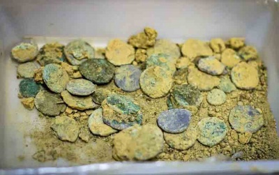 A strip of gold running across the block in the centre of this picture alerted conservators to the presence of gold torques among the coins