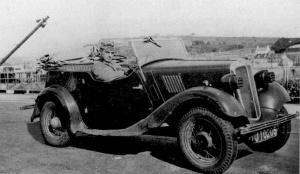 A German soldier with a 'requisitioned' Morris 8